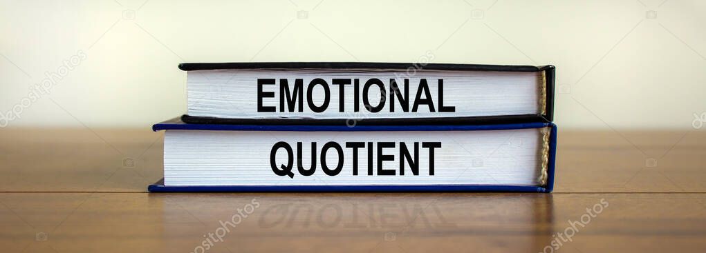 Books with text 'emotional quotient' on beautiful wooden table. White background. Business concept.