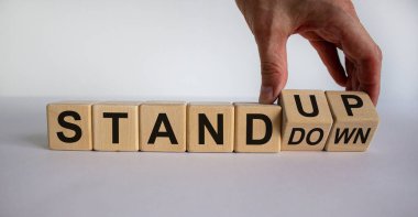 El bir küpü döndürür ve 'geri çekil' ifadesini 'ayağa kalk' olarak değiştirir. İş konsepti. Güzel beyaz arkaplan, kopyalama alanı.