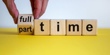 El bir zar çeviriyor ve 'tam zamanlı' kelimesini 'yarı zamanlı' ya da tam zamanlı olarak değiştiriyor. Güzel sarı masa, beyaz arka plan. İş konsepti. Boşluğu kopyala.