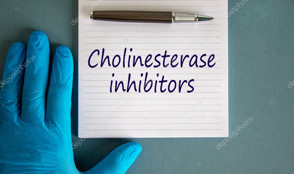 Hand in blue glove, pen, white note with words 'cholinesterase inhibitors'. Beautiful blue background.