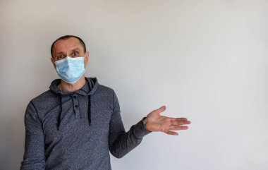 Sürprizin ifadesi. Beyaz arka planda izole edilmiş koruyucu ilaç maskesi takan genç bir adam. Uzayı kopyala Tıbbi konsept.