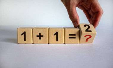 Matematik öğretiyorum. El küpü çevirir, çözer ve denklemi çözer. İş ve eğitim kavramı. Güzel beyaz arkaplan, kopyalama alanı.