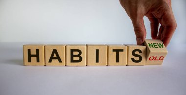 Erkek el küpü çeviriyor ve 'eski alışkanlıklar' ifadesini 'yeni alışkanlıklar' a çeviriyor. Güzel beyaz arka plan. Kavram. Boşluğu kopyala.