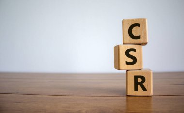 Tahta masadaki tahta küplerin CSR kısaltması. Kurumsal Sosyal Sorumluluk. Fotokopi alanı ve iş konseptiyle güzel beyaz arkaplan.