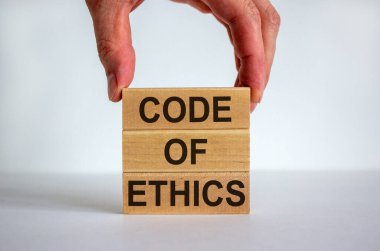 Erkek el, blok kulesinin tepesine 'kod' yazan bir blok yerleştiriyor. 'Ahlak kuralları' metni. Güzel beyaz arka plan. Boşluğu kopyala.