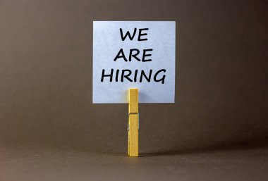 Beyaz kağıtlı ahşap mandal. Eleman arıyoruz diye mesaj at. Güzel gri arkaplan. İş konsepti, kopyalama alanı.