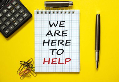 Güzel sarı arka plan, renkli ataçlar, metal kalem, kapak ve hesap makinesine yardım etmek için buradayız yazılı beyaz bir not. İş konsepti.