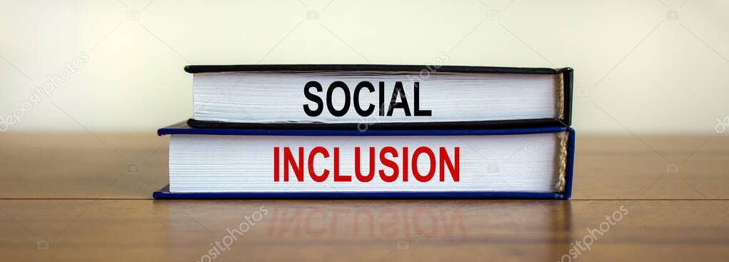 Books with text 'social inclusion' on beautiful wooden table. White background. Business concept. Copy space.