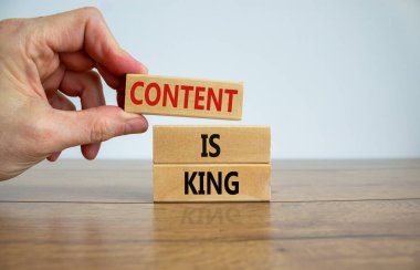 Bir bloğun tepesine 'içerik' sözcüğünün yazılı olduğu bir bloğu 'içerik' sözcüğü ile yerleştirmek krallıktır. Tahta masa. Güzel beyaz arka plan. Uzayı kopyala İş konsepti.