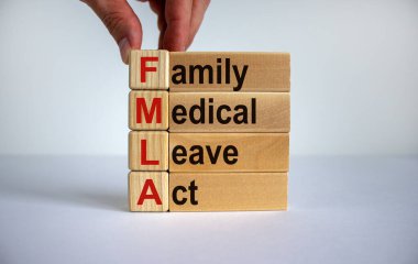 Concept words 'FMLA, family medical leave act' on cubes and blocks on a beautiful white background. Male hand. Copy space. Medical concept. clipart