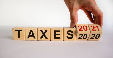 İş planı 2021. Erkek el ahşap küpleri çevirir ve 'Vergi 2020' yazısını 'Vergi 2021' olarak değiştirir. Güzel beyaz arkaplan, kopyalama alanı.