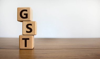 Güzel ahşap bir masa üzerinde 'GST, ürün ve hizmet vergisi' kavramları, beyaz arka plan. İş konsepti. Boşluğu kopyala.