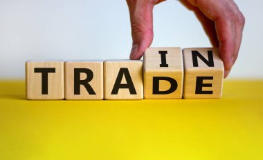 El küpleri çevirir ve 'tren' kelimesini 'ticaret' olarak değiştirir. Güzel ahşap masa, beyaz arka plan, fotokopi alanı. İş konsepti.