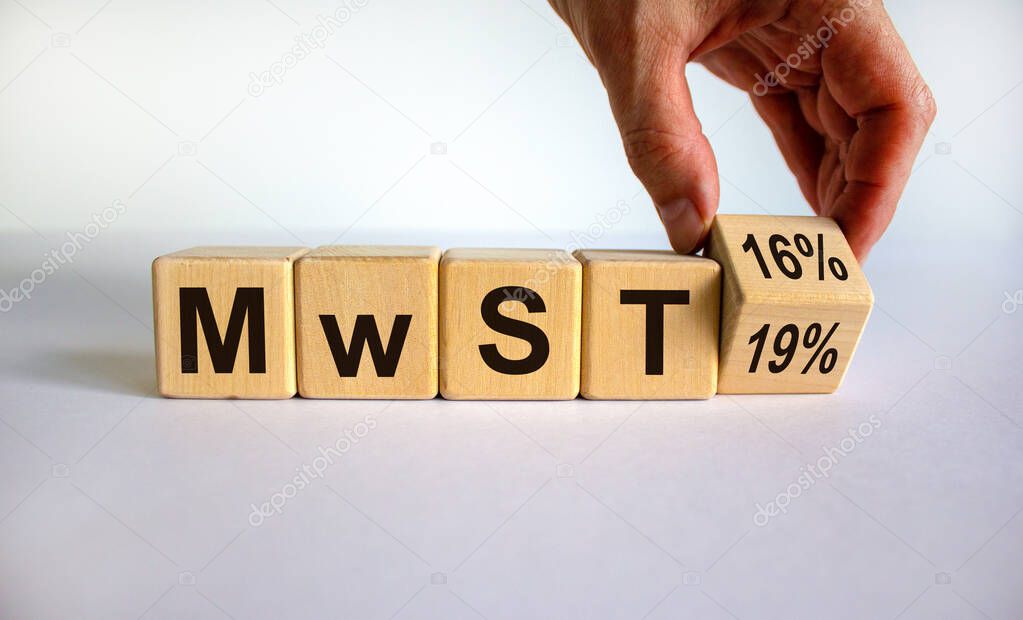 German stimulus packages after the corona crisis. Hand turns a cube and changes the expression 'MwST 19' to 'MwST 16'. Beautiful white background.  Copy space.