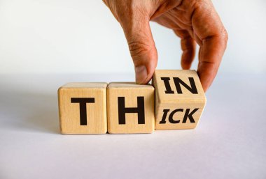 El küpü çevirir ve 'kalın' kelimesini 'ince' ya da tam tersi olarak değiştirir. Güzel beyaz arka plan. Kavram. Boşluğu kopyala.