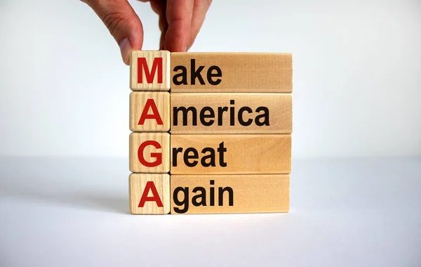 コンセプトワード Maga Make America Great Again アメリカを再び偉大にする 木製の立方体と美しい白い背景のブロック 男性の手 スペースのコピー — ストック写真