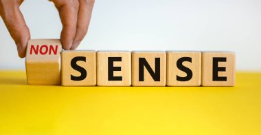 El küpü çevirir ve 'saçmalık' kelimesini 'mantık' ya da tam tersi olarak değiştirir. Güzel sarı masa, beyaz arka plan. Kavram. Boşluğu kopyala.