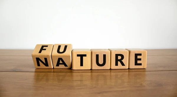 Turned a cube and changed the word \'future\' to \'nature\' or vice versa. Beautiful wooden table, white background. Copy space, concept.
