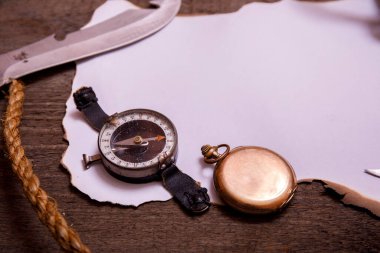 Eski kağıt, pusula, bıçak ve ip eski ahşap masa üzerinde. Metnin için boş alanın üst görünümü.