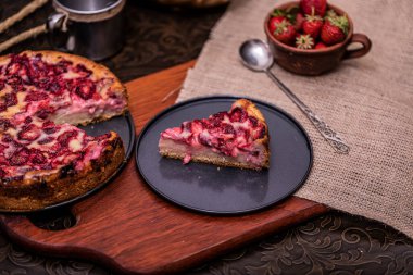 Çilekli kek turtası ve koyu arkaplanlı krem şanti. Yumuşak odaklı, lezzetli manzaralı.