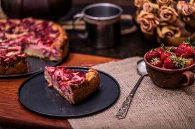 Çilekli kek turtası ve koyu arkaplanlı krem şanti. Yumuşak odaklı, lezzetli manzaralı.