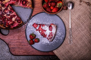 Ev yapımı çilekli pastalar, tabaktaki yaz meyveleri eski ve karanlık ahşap dramatik arka planda tuval. Seçici odaklanma. Menü, pankart, poster, maket. Mutfağın kırsal tarzı.