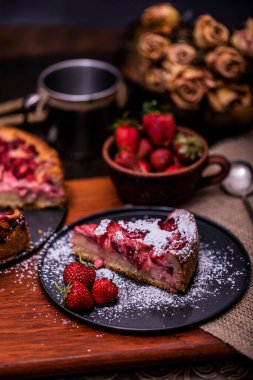 Ev yapımı çilekli pastalar, tabaktaki yaz meyveleri eski ve karanlık ahşap dramatik arka planda tuval. Seçici odaklanma. Menü, pankart, poster, maket. Mutfağın kırsal tarzı.