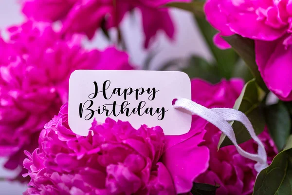 Happy Birthday greeting card on pink flower. Roses flowers and petals background.