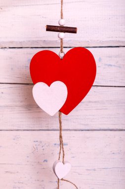 Boyanmış beyaz tahtalarda asılı kırmızı romantik ahşap bir kalp. Kalpler ipte sallanıyor. Sevgililer Günü tebrik kartı. Aşk konsepti