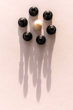 Beyaz arka planda taç şeklinde gölgesi olan plastik satranç piyonu çemberi. Takım çalışması, grup anlaşması ve başarı kavramı