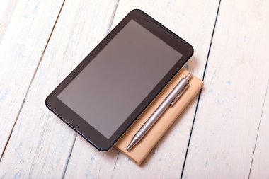 Shabbi beyaz tahta masa ve kalem üzerinde defter olan tablet