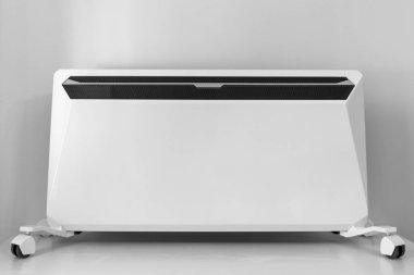 Kışın evde ısıtıcı kullanmak. Isıtma mevsimi. Evde kontrol paneli olan modern elektrikli ısıtıcı..