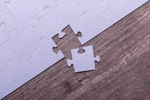 Jigsaw puzzle pieces lying on old wooden rustic boards. Conceptual of innovation, solution finding and integration.