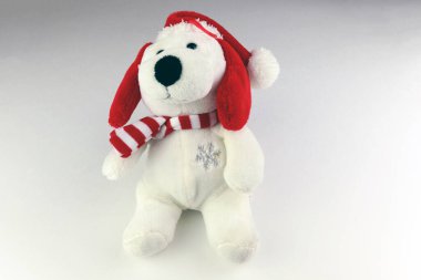 Beyaz arka planda izole edilmiş Noel Baba şapkası takan oyuncak ayı.