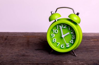 Ahşap masadaki antika yeşil alarmlı saat. Mesajın için boş yer var. Çifte zilli klasik..