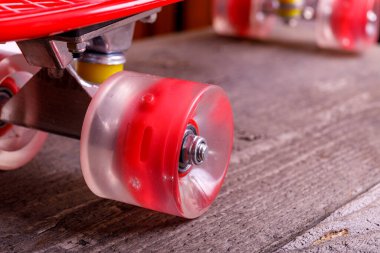 Plastik kırmızı kaykay tekerleri ahşap zemine yakın..