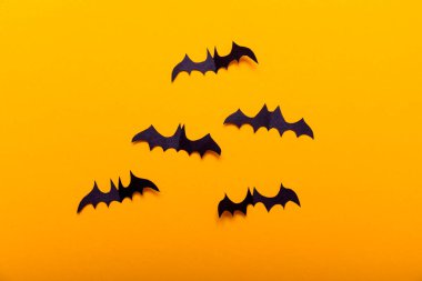 Cadılar Bayramı konsepti için el sanatları. Siyah yarasa figürleri, sarı arka plandaki siyah kağıttan kesilmiş. Metin için yer Üst Görünümü Düzenle