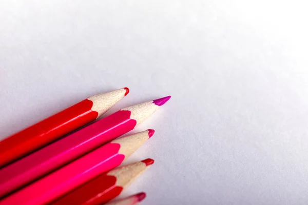 One sharpened pencil standing out from the blunt ones. It\'s easy to be beautiful if you do nothing concept. Red pencils on white.