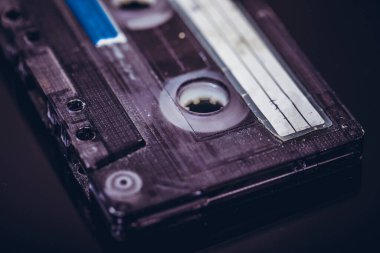 Siyah arkaplandaki retro ses konakt kasedini kapat. Eski ses kaseti, seçici odak resmi.