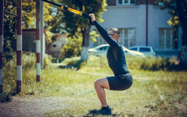 Antrenman sırasında sokakta askılarla gezen bir adam.