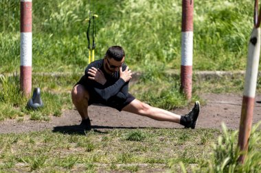Sağlıklı bir adam dışarıda geriniyor, denizi görüyor. Spor ve spor konsepti. Dışarıda yoga yapan bir adam..