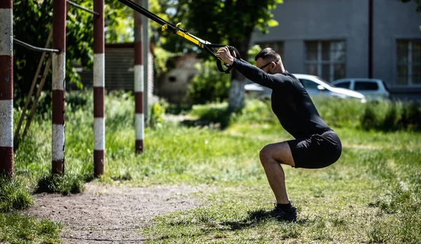 Jovem Atrativo Faz Treinamento Suspensão Com Alças Fitness Livre Natureza — Fotografia de Stock