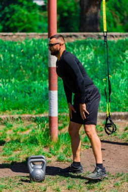 Kettlebell halter formda adam spor salonunda bacak egzersizi için ağırlık kaldırıyor..