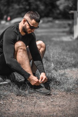 Koşu ayakkabısı bağlayan koşucu. Kardiyo çalışmak ya da kilo vermek.
