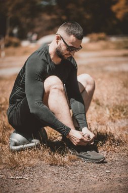 Koşu ayakkabısı bağlayan koşucu. Kardiyo çalışmak ya da kilo vermek.