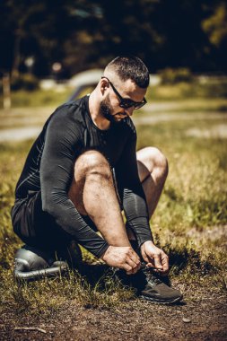 Koşu ayakkabısı bağlayan koşucu. Kardiyo çalışmak ya da kilo vermek.