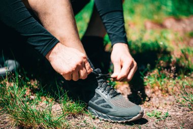 Dışarı çıkmadan önce bağcıklarını bağlayan çekici bir genç adam.