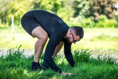 Yakışıklı, kaslı, güçlü bir adam göl kenarında yoga yapıyor. Konsantre yetişkin sporcu şınav çekiyor..