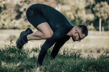 Germe ellerde ve park yeşil çimenlerin üzerinde dostum. Atlet açık havada egzersiz yapmak. Spor, yoga, pilates, fitness, sağlıklı yaşam konsepti.