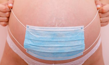 Covid 19 ncov koronavirüs ve salgın virüs belirtileri. Karnını kapat ve bebeği korumak için cerrahi maske tak. Karantinayı durdurun..